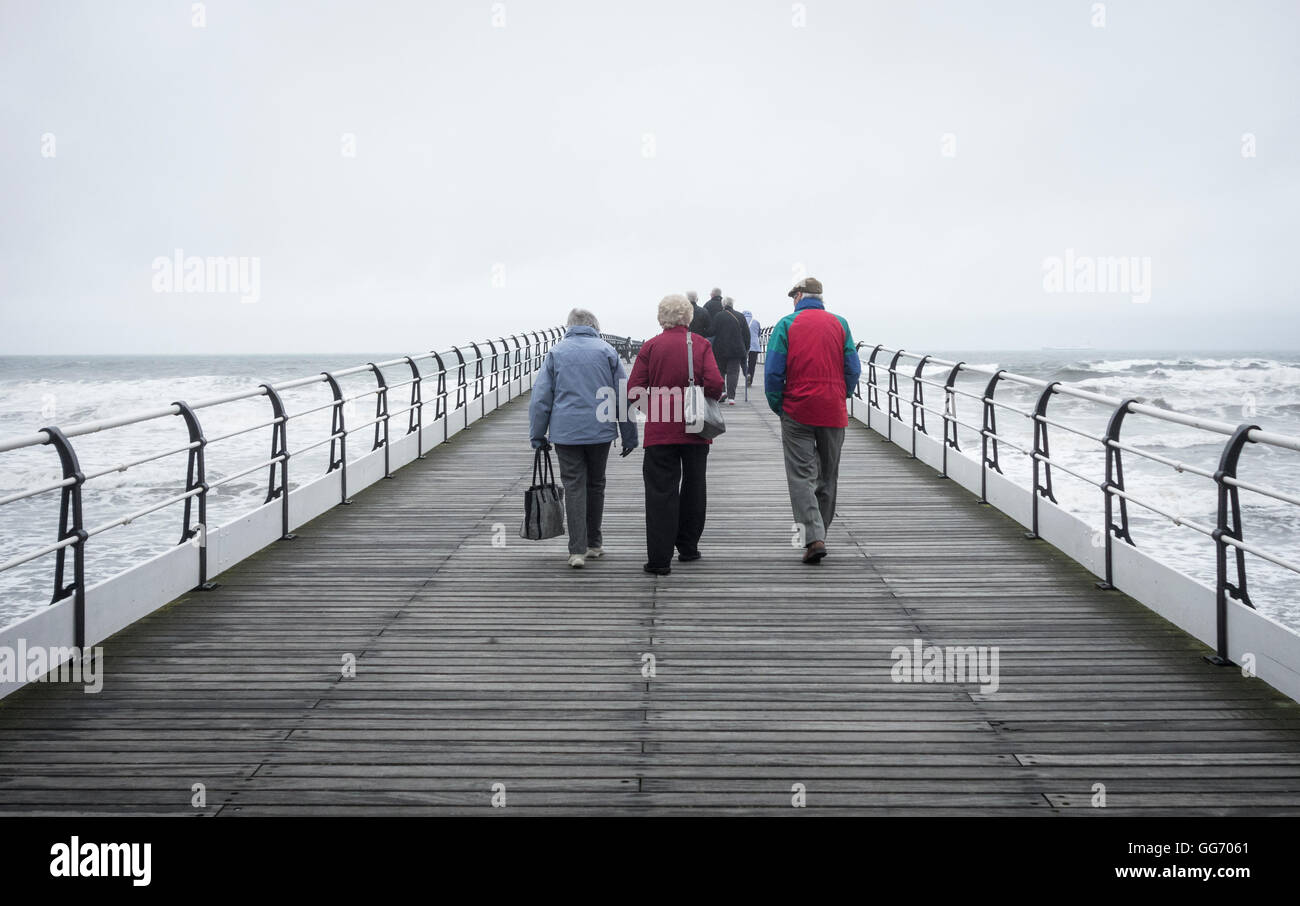 People walking on Saltburn`s Victorian pier on a cold, grey October day. Saltburn by the sea, England. UK Stock Photo